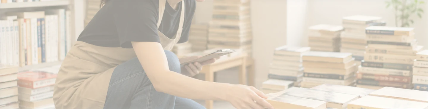 積み上げられた本を査定するスタッフ